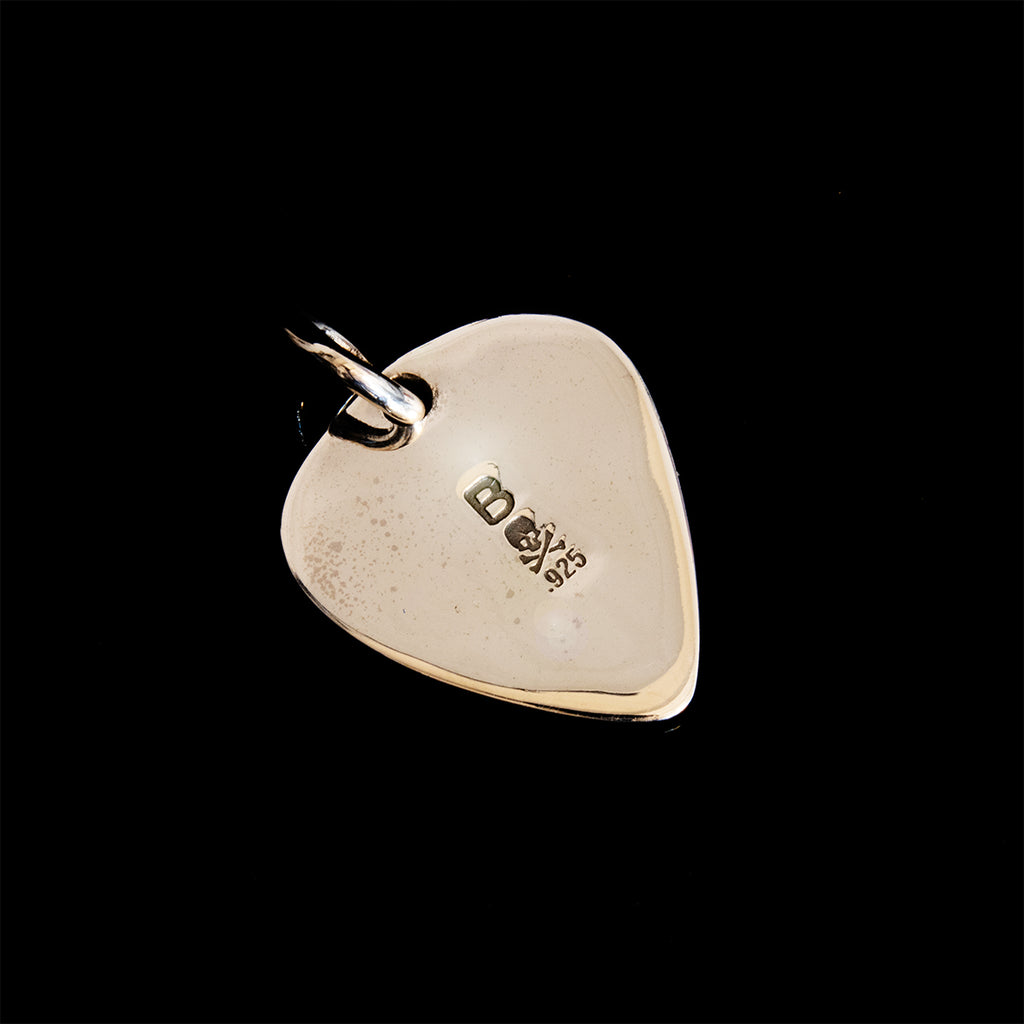 back of a silver guitar pic pendant on black