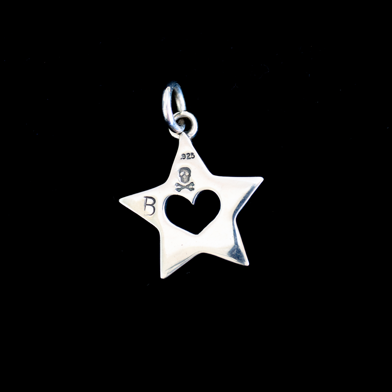 back side of heart cutout of star pendant on black. 