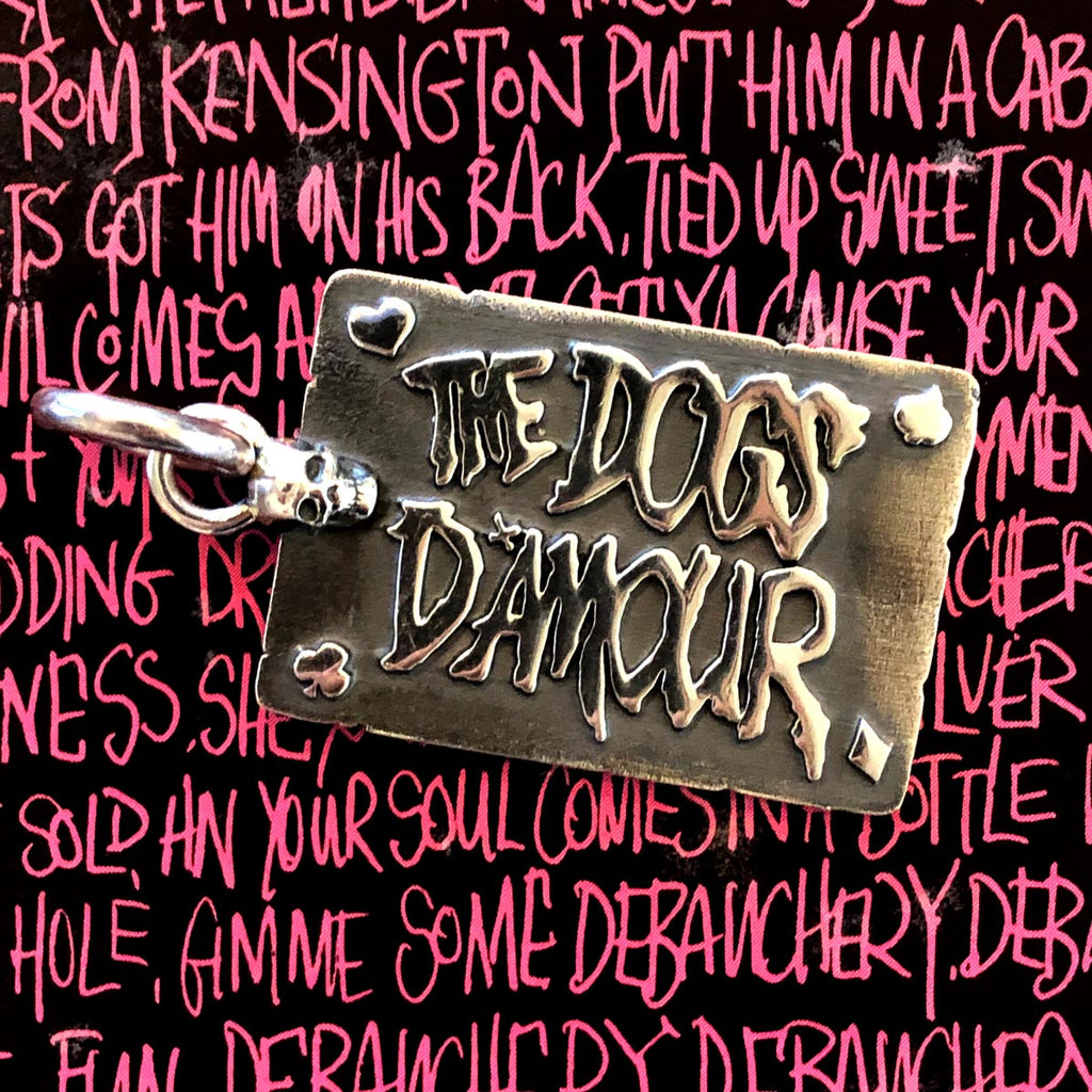 dogs damour pendant laid on top of dogs d'amour lyrics.