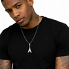 Man wearing a black t-shirt wearing a flying v guitar pendant. 