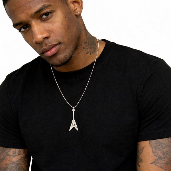 Man wearing a black t-shirt wearing a flying v guitar pendant. 