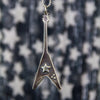 Silver Flying V Pendant against a blurry star background.