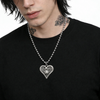 Person wearing a black shirt with a silver necklace featuring a heart-shaped pendant.