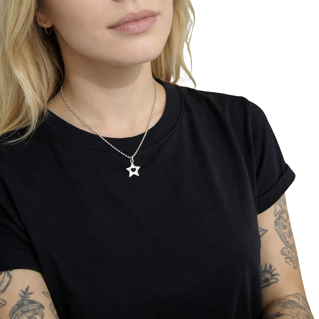 Person wearing a black t-shirt with a star-shaped pendant necklace on a white background