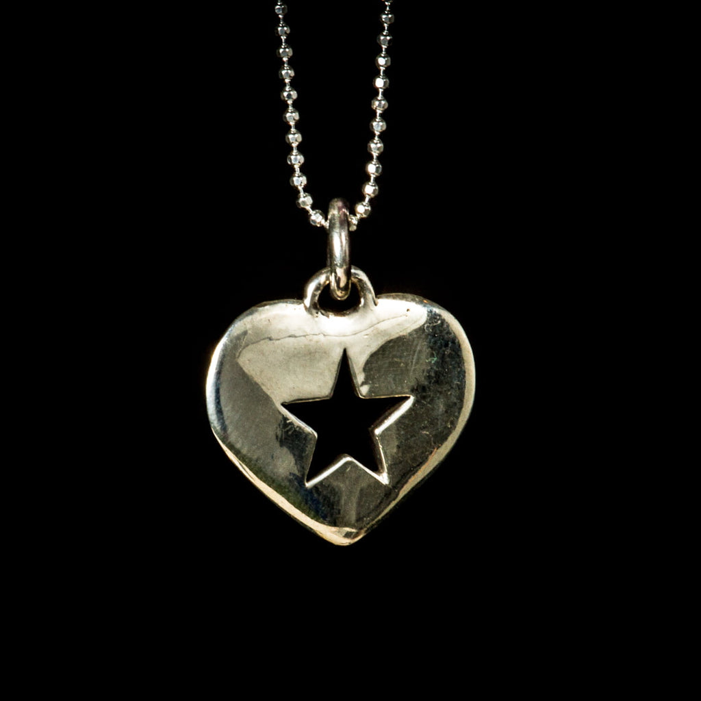 Silver heart-shaped pendant with a star design on a black background