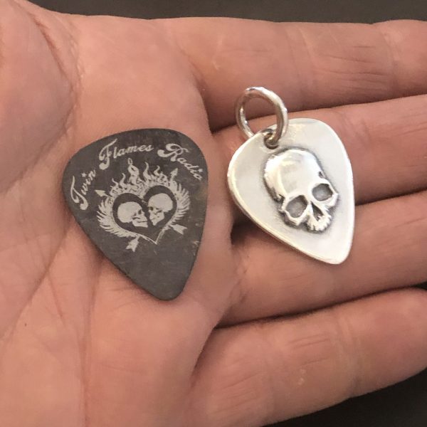 Guitar Pic Skull next to a real guitar pic