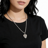 Person wearing a black shirt with a silver necklace featuring a guitar pic pendant with a star. 