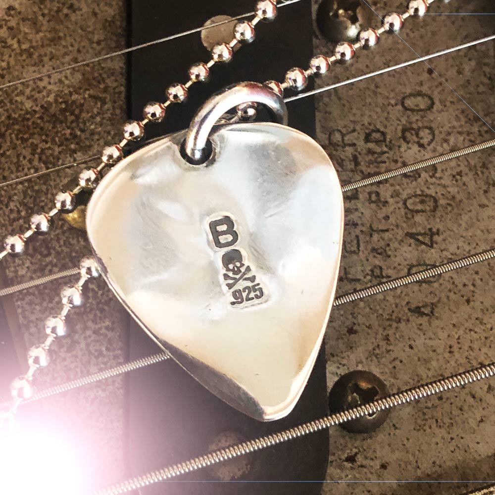 Silver Star Guitar Pic Pendant on a guitar.