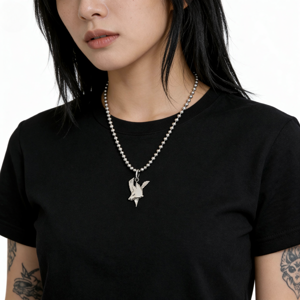 Person wearing a black t-shirt with a necklace featuring a vixen band logo fox pendant.